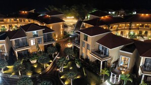 A well-lit, multi-story residential complex with balconies and a central courtyard. - Vaikunth Village Resort (Abhanpur)