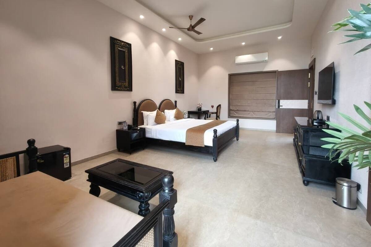 A modern hotel room with a bed, bedside table, and a desk.