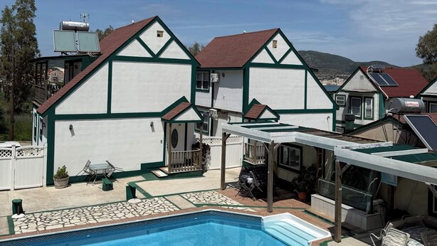 Une propriété résidentielle dotée d’une piscine, d’un patio couvert et d’un garage.
