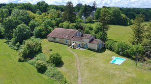 An aerial view of a stone house with a tiled roof, surrounded by lush greenery and a small swimming pool. - Beautifully restored Farmhouse in the heart of the countryside with private pool (Bourg des Maison)
