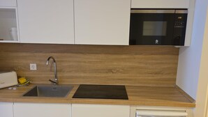 Una cocina con encimera de madera, un fregadero, un microondas y un lavavajillas.