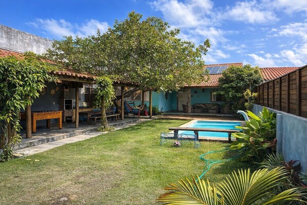 A backyard with a swimming pool, a barbecue area, and a covered seating area. - Porto de Galinhas - Serrambi Beach with swimming pool 280m from the sea. (Camela)