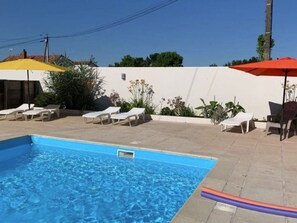 A swimming pool with lounge chairs and umbrellas. - Mobile Home with Terrace for 4 People (Arvert)