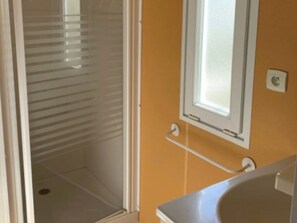 A bathroom with a shower, a window, and a towel rack. - Mobile Home with Terrace for 4 People (Arvert)
