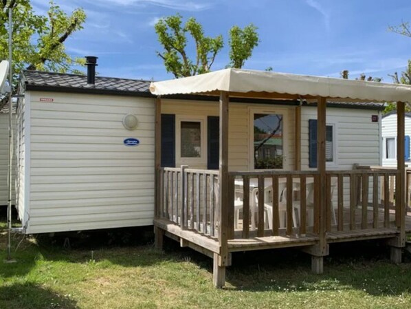 A mobile home with a wooden deck and a covered porch. - Mobile Home with Terrace for 4 People (Arvert)