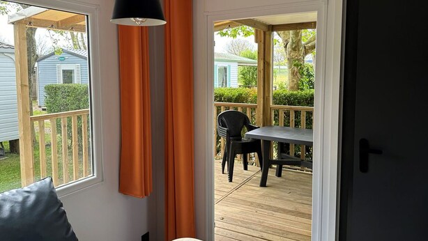 A bedroom with a view of an outdoor deck and a patio area. - Mobile Home with Terrace, Ideal for 4 (Arvert)