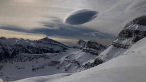 Un paysage montagneux enneigé, avec un sommet bien visible et un ciel dégagé.
