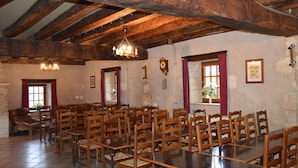 A large hall with wooden tables and chairs, a chandelier, and a clock on the wall. - Countryside home near Châteauroux, family-friendly (Arthon)