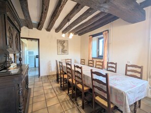 A dining room with a long table, wooden chairs, and a chandelier. - Countryside home near Châteauroux, family-friendly (Arthon)