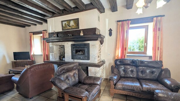 A living room with leather sofas, a fireplace, and a television. - Countryside home near Châteauroux, family-friendly (Arthon)