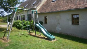 A residential building with a green slide and swings in the yard. - Countryside home near Châteauroux, family-friendly (Arthon)