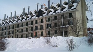 A multi-story hotel with a row of balconies and a row of chimneys. - Modern Studio in Candanchú, 4 ppl, 2 beds (Aisa-Candanchú)