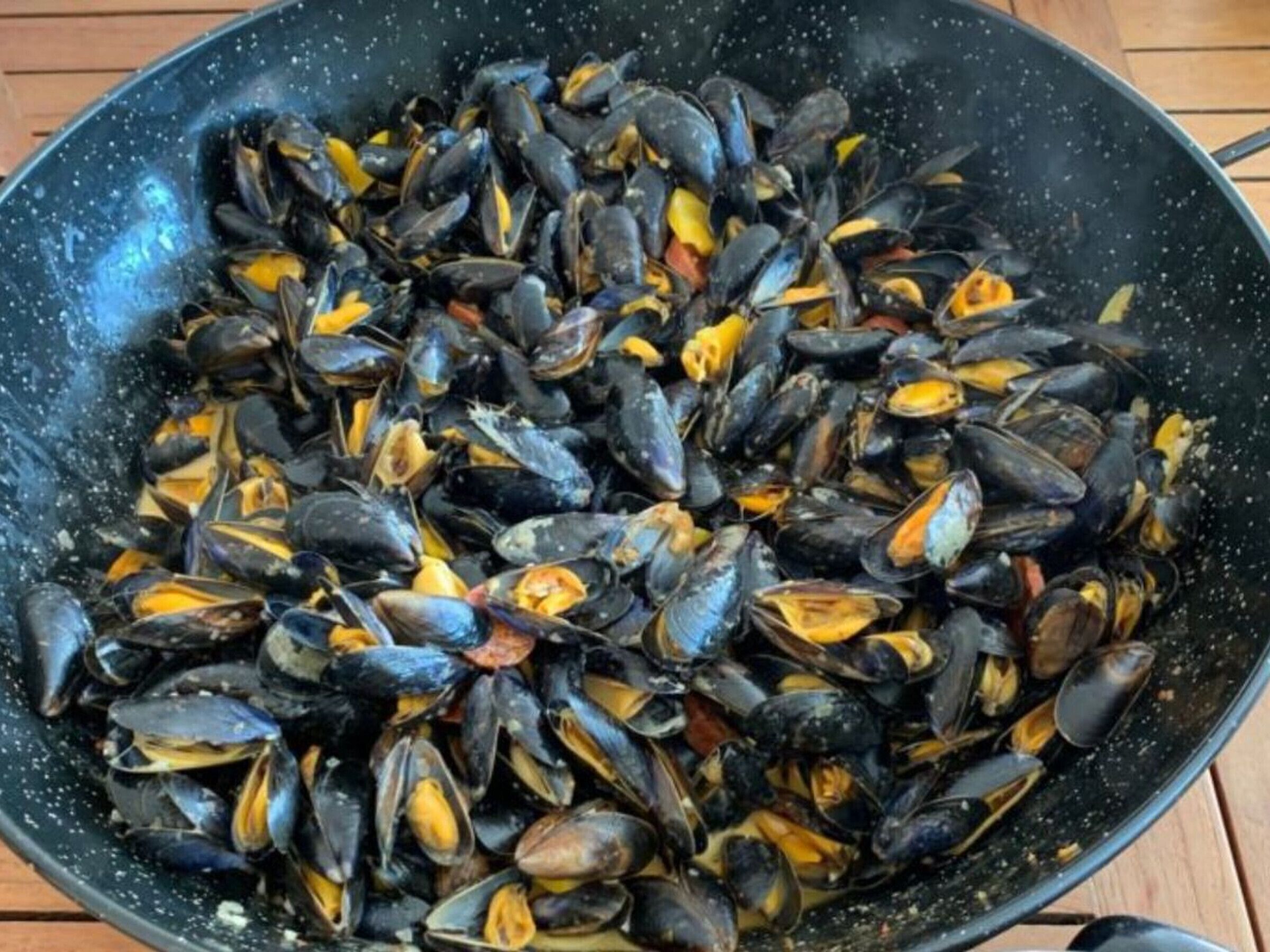 A large black pan filled with mussels.
