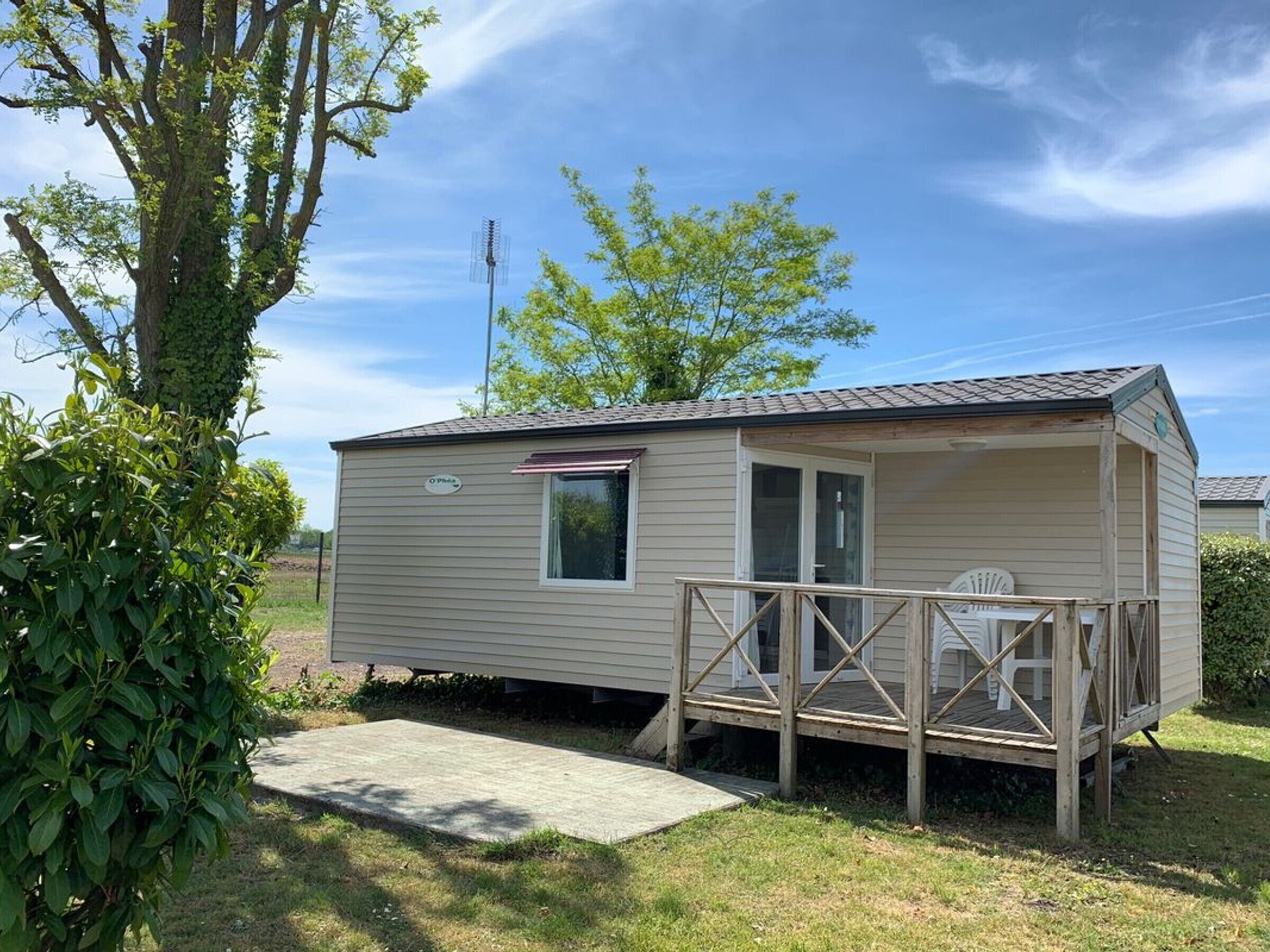 A small, single-story mobile home with a porch and a small window.