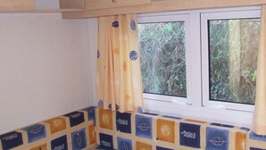 A kitchen with a window, a patterned backsplash, and wooden cabinets.