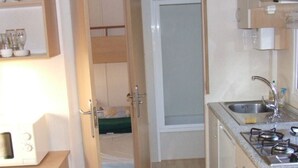 A compact kitchen with a sink, stove, and cabinets.