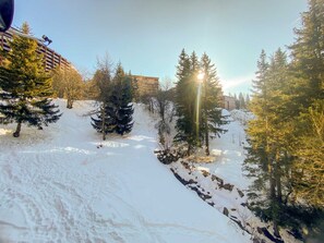A snowy outdoor area with trees and a building in the background. - Arc 1800 - Apartment 6 pers, 74m², WIFI (Les Arcs 1800)