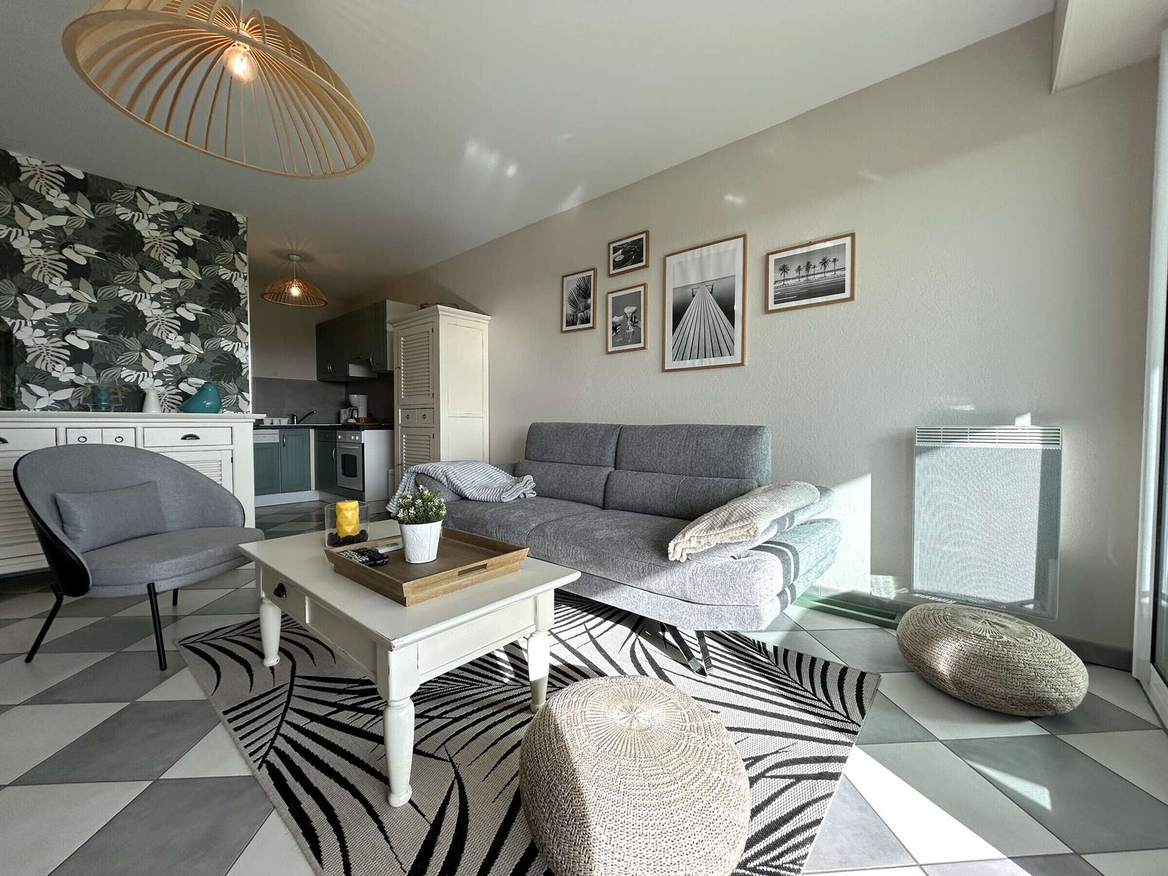 A modern living room with a grey sofa, a white coffee table, and a patterned rug.