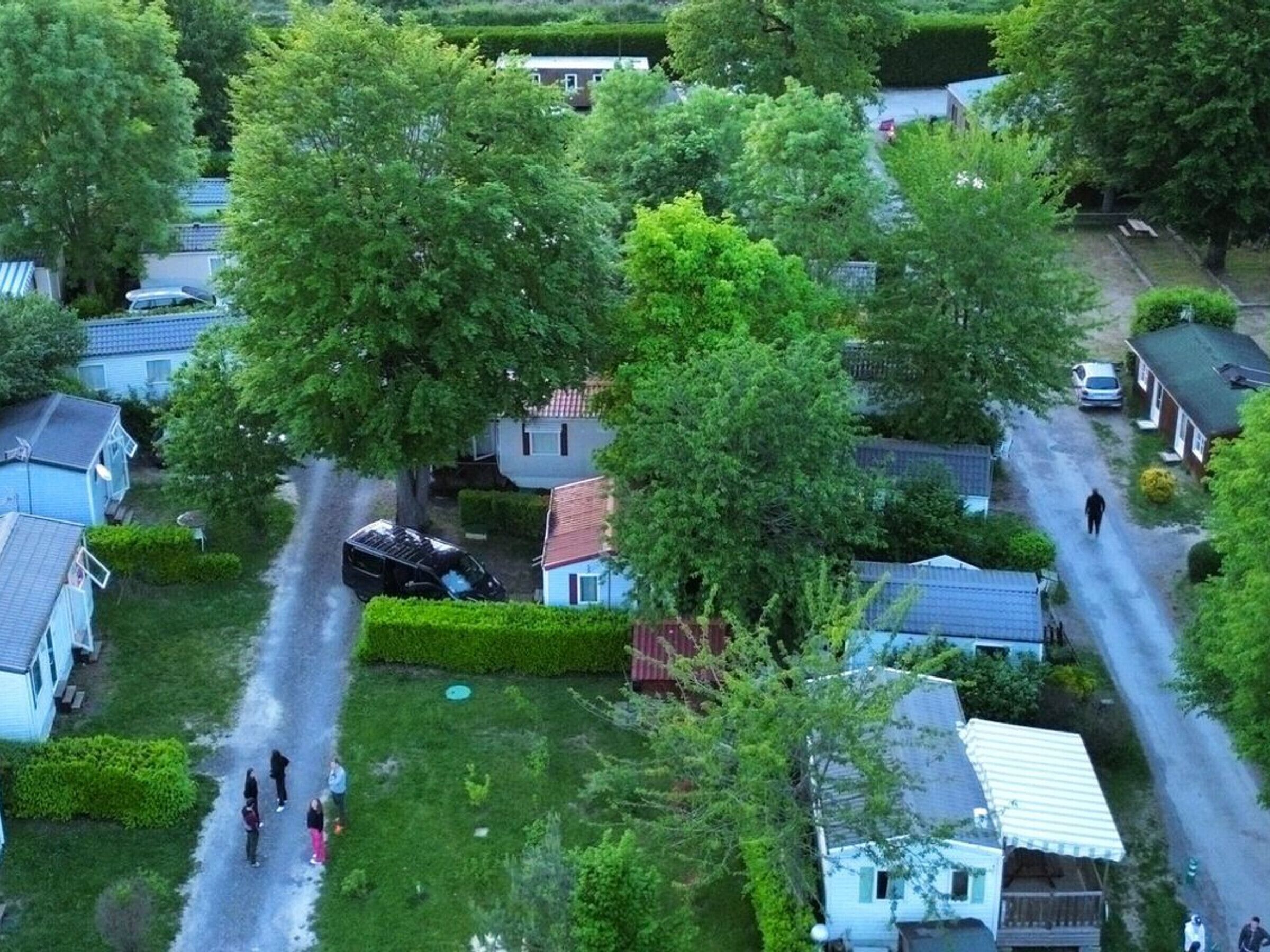 Un quartier résidentiel avec des maisons, une allée et une personne qui marche.
