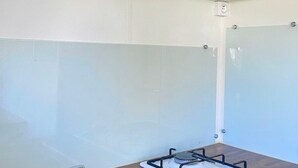 A kitchen with white cabinets, a gas stove, and a white backsplash. - 20m² Mobile Home for 2 Guests (Angicourt)