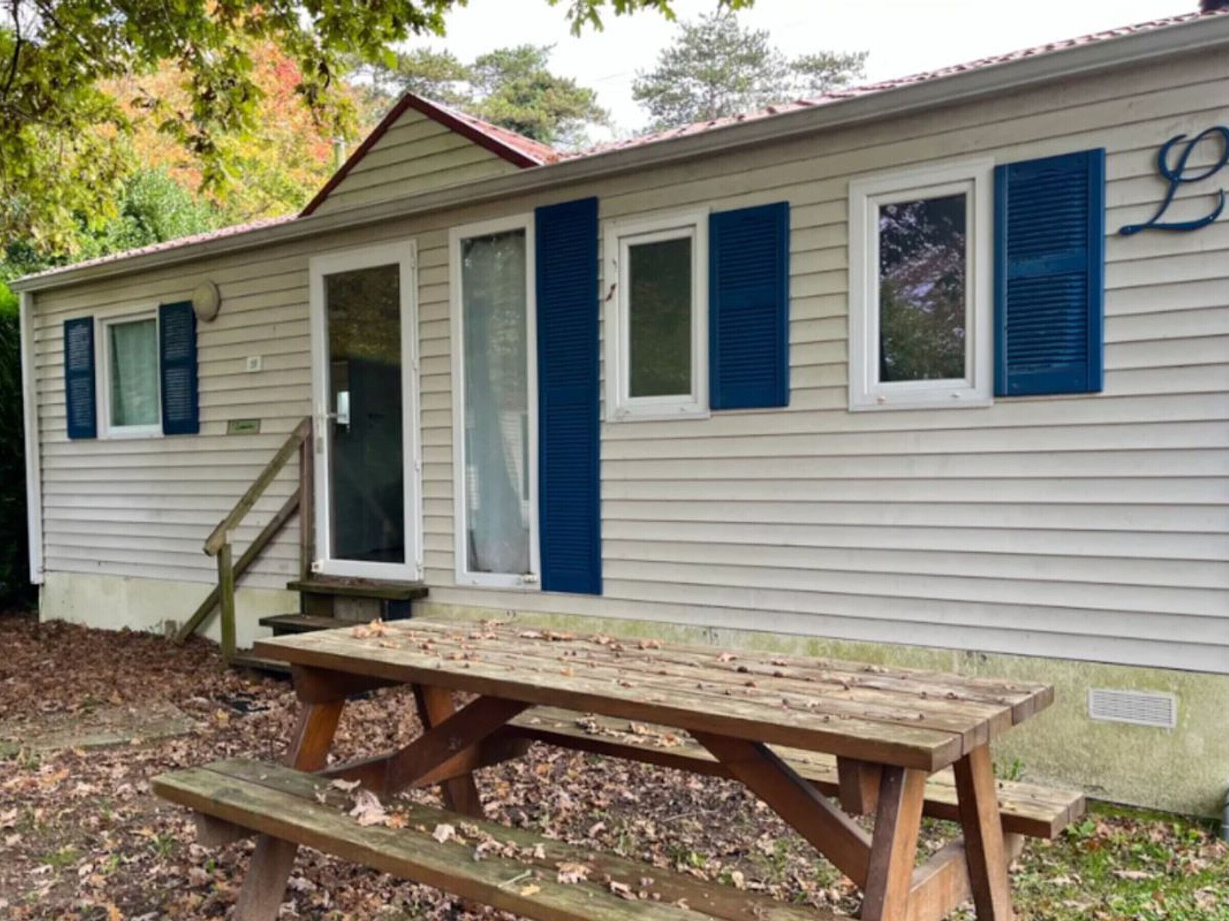 A single-story building with a porch and a picnic table.