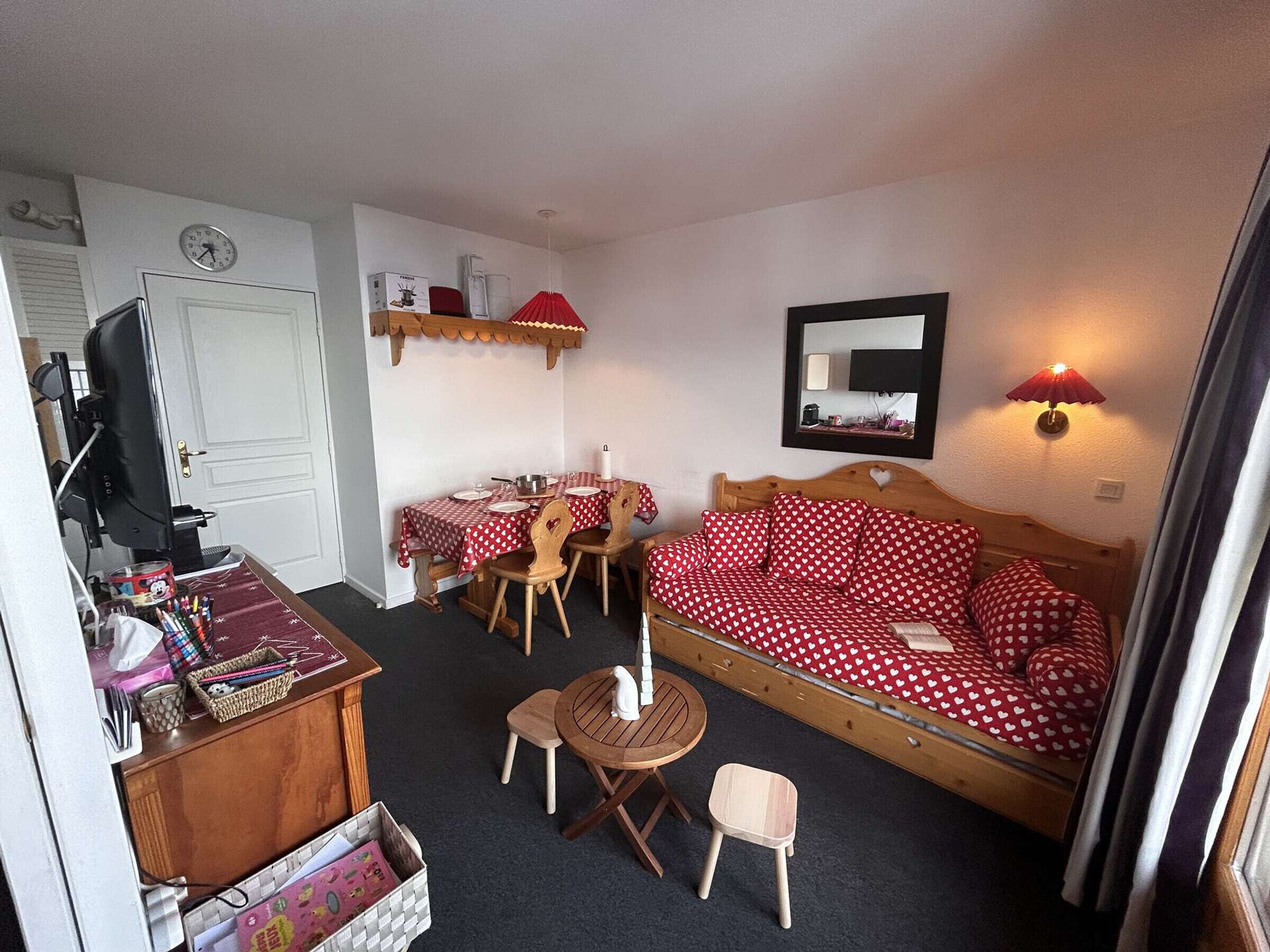 A compact room with a bed, a dining table, and a TV.