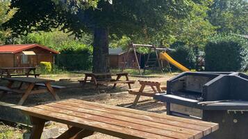 Un área de picnic con bancos de madera y una parrilla.