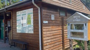 A wooden building with a sign reading "BOITE A LIVRES" and a poster advertising "La Falouse". - Family Mobile Home for 5 in Angicourt (Angicourt)