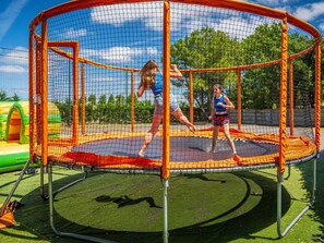 A trampoline enclosure with a safety net, surrounded by artificial grass. - 30m² Mobile Home for 6 with Terrace in Saint-Hilaire-de-Riez (Saint-Hilaire-de-Riez)