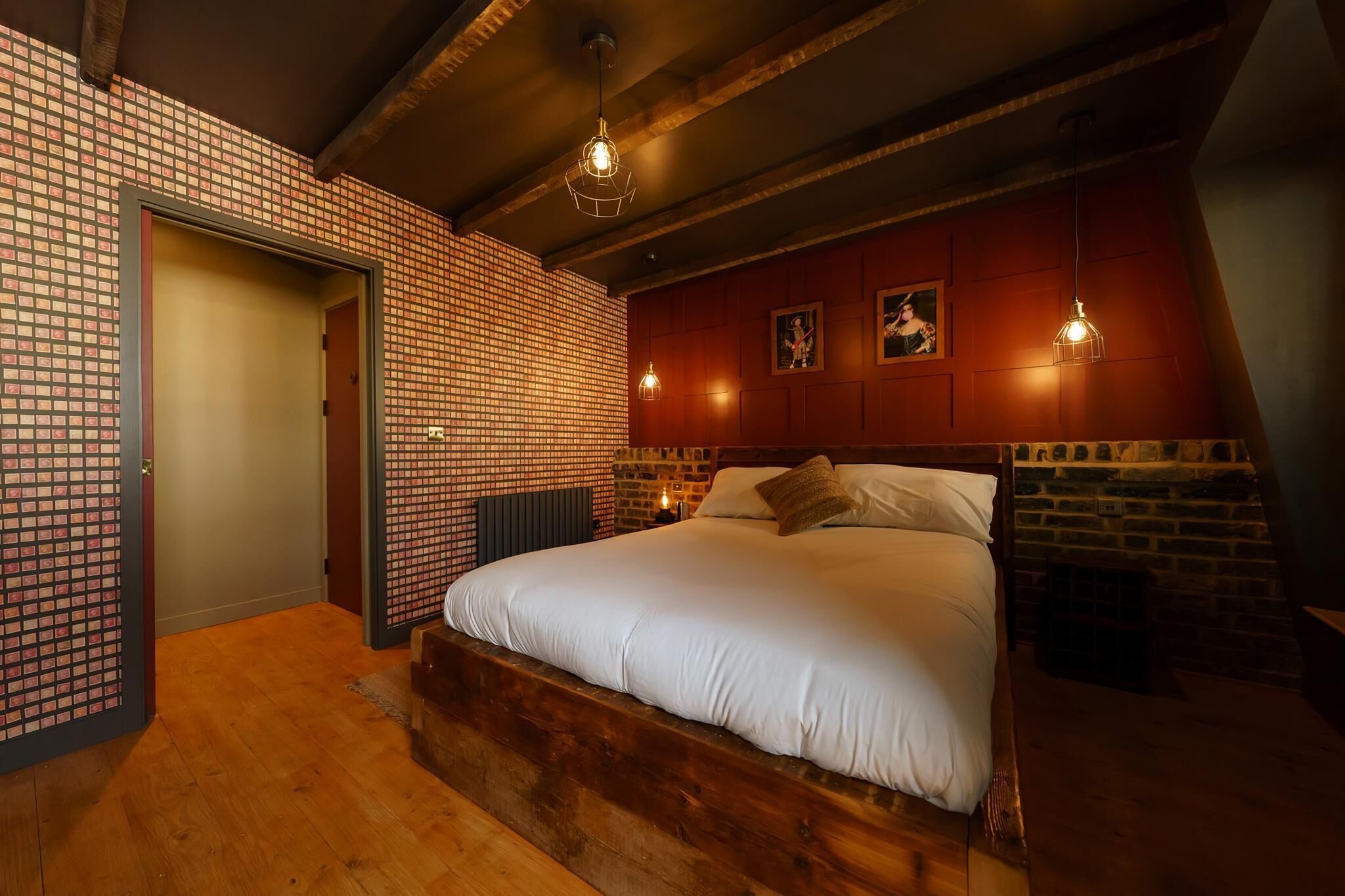 Ein Schlafzimmer mit einem hölzernen Bett, einer Wand mit Backsteinmuster und einem Kamin.
