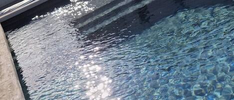 Ein klares Schwimmbecken mit guter Sichtbarkeit und einer gefliesten Kante.