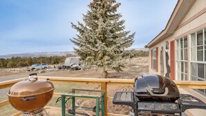 A deck with a grill and a view of a house and a tree. - Hike, Fish & Unwind: Mtn-view Gem in Cedaredge! (Cedaredge)