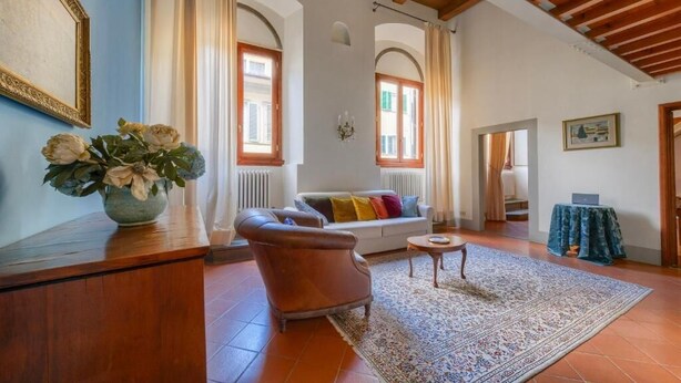 Un soggiorno ampio con un divano, un tavolino in legno e un tappeto decorato.