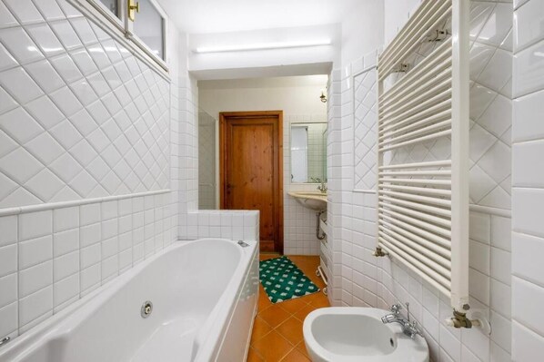 A bathroom with a bathtub, a sink, and a shower area. - Firenze Rentals Dodi Duomo (Florence)