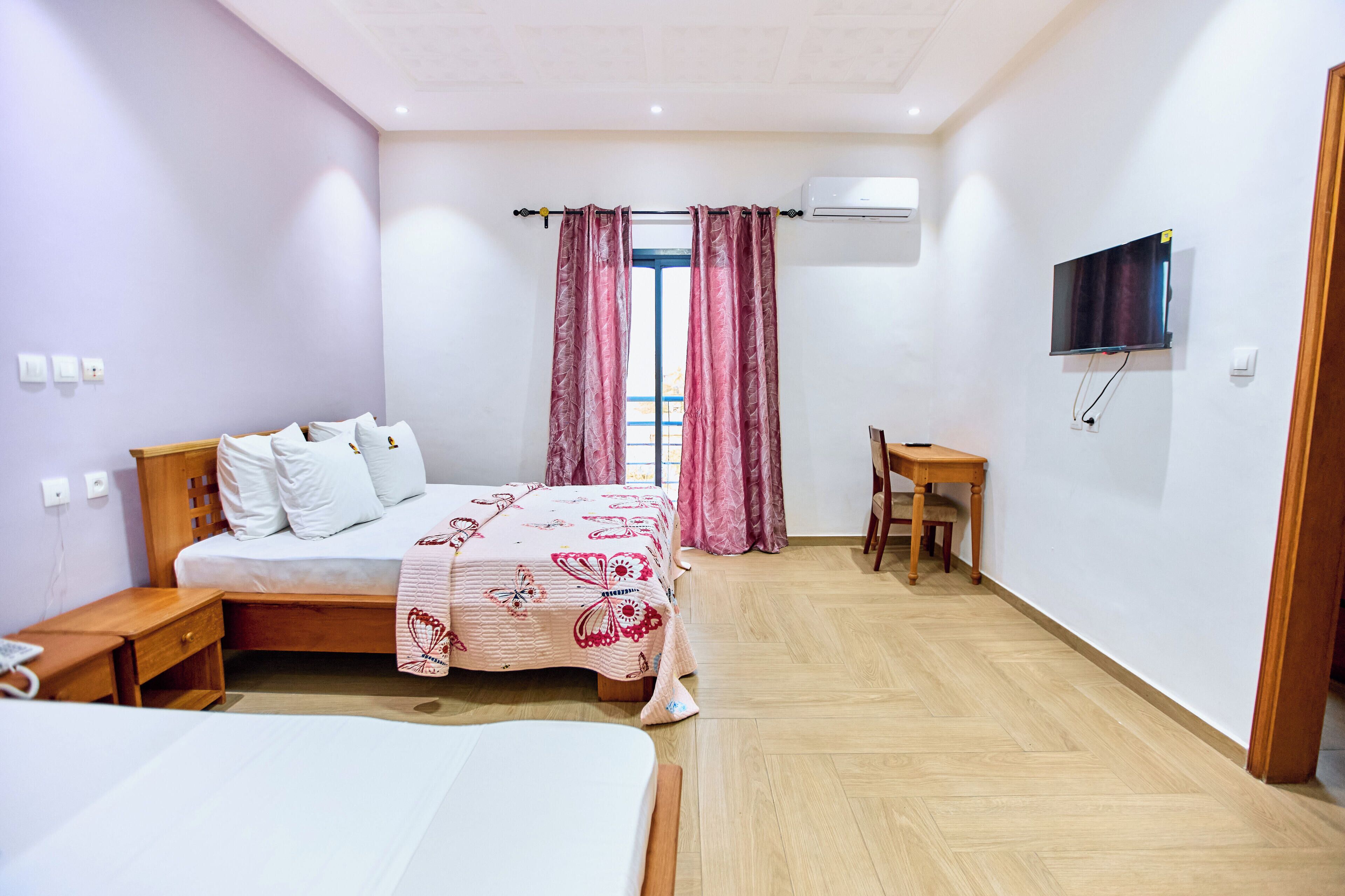 A bedroom with a bed, bedside table, and a desk with a chair.