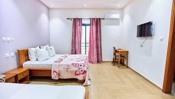A bedroom with a bed, bedside table, and a desk with a chair.