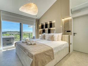 A modern bedroom with a large bed, a balcony with a view, and a ceiling light fixture.