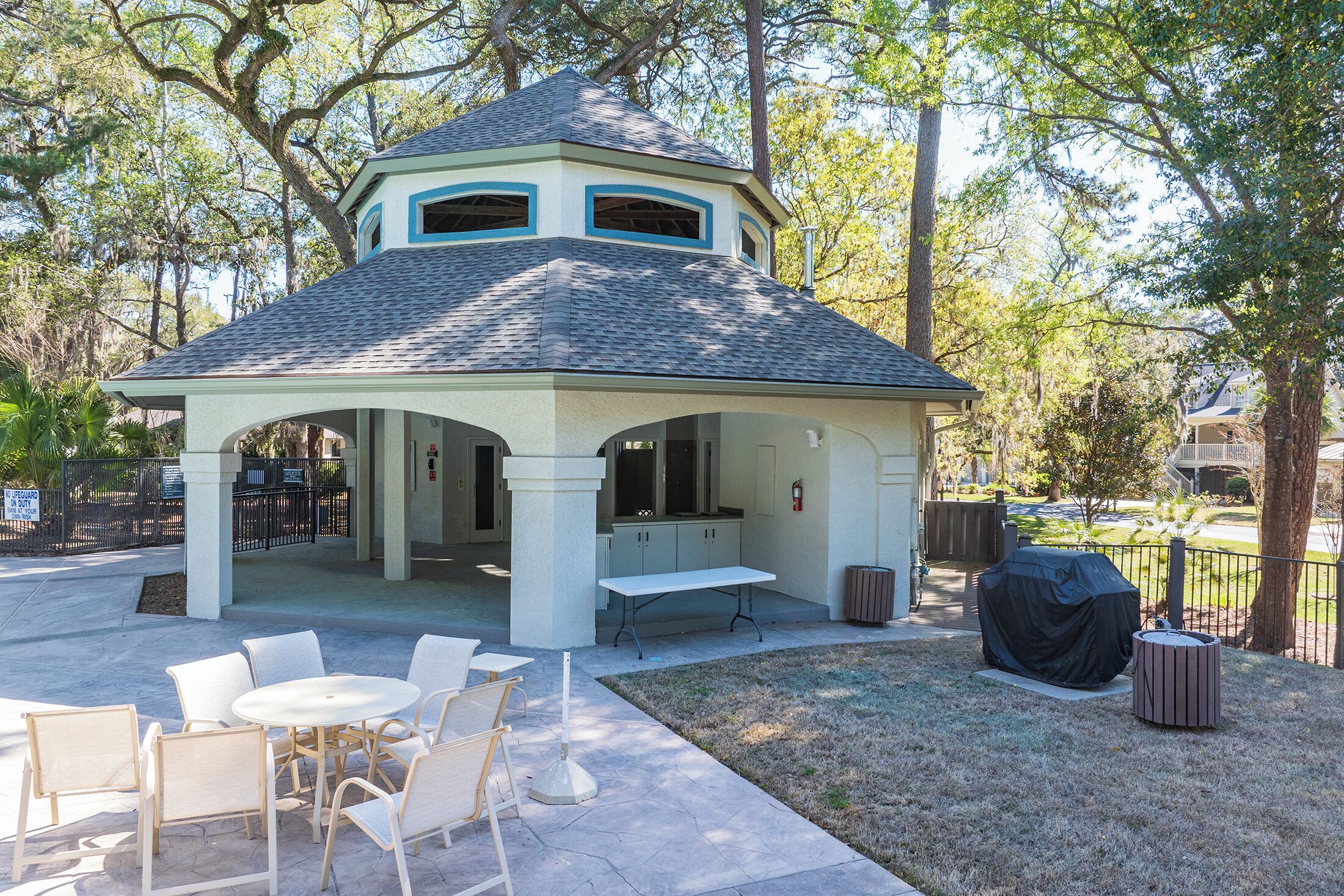 A gazebo with a covered patio, outdoor seating, and a barbecue grill.