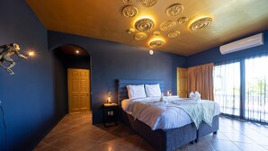 A bedroom with a bed, nightstands, a wall-mounted light fixture, and a large window with curtains. - The Ambassador Full Building (Jan Thiel)
