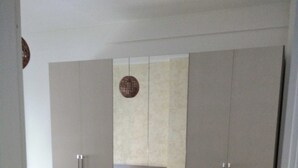 A bedroom with a bed, a small bedside table, and a wardrobe. - Beautiful Apartment 1br/4p - At the Gates of Milan (Sesto San Giovanni)