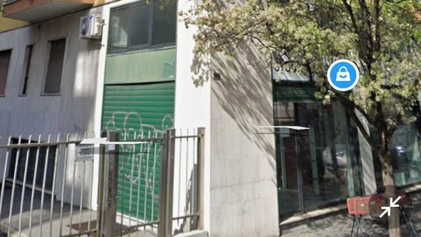 A multi-story residential building with balconies and a green gate. - Beautiful Apartment 1br/4p - At the Gates of Milan (Sesto San Giovanni)