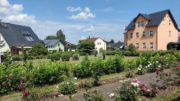 Ein Wohngebiet mit Häusern, einem Rosengarten und einem gepflasterten Weg.