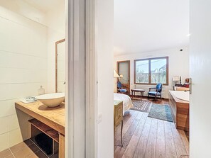 A modern bathroom with a large sink, wooden vanity, and a bathtub. - Kervourden by Interhome (La Trinité Sur Mer)