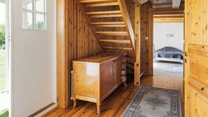 Un interior de fusta amb una escala, un armari i un llit.