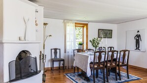 Zona de menjador amb taula de fusta preparada per a quatre persones, envoltada de cadires.