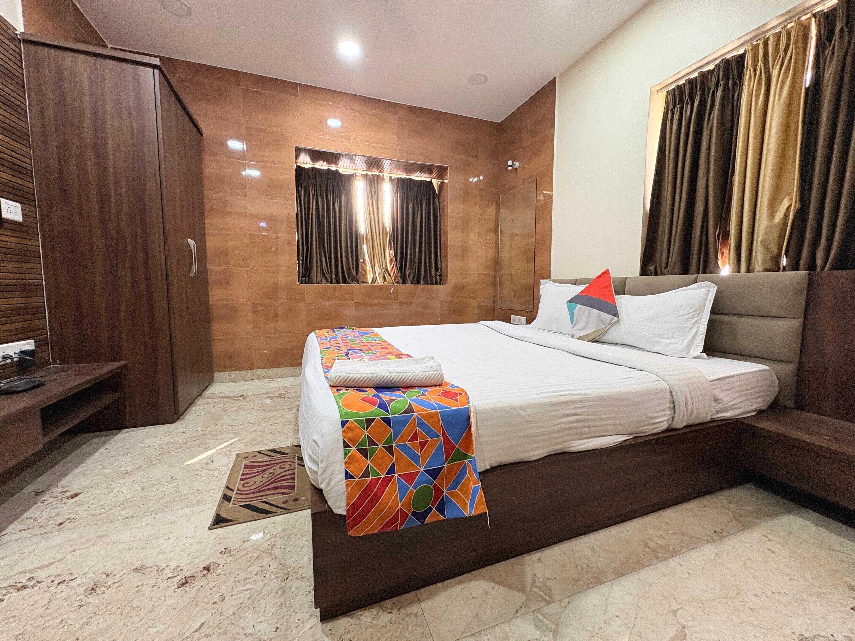 A modern bedroom with a large bed, a wardrobe, and a small desk.
