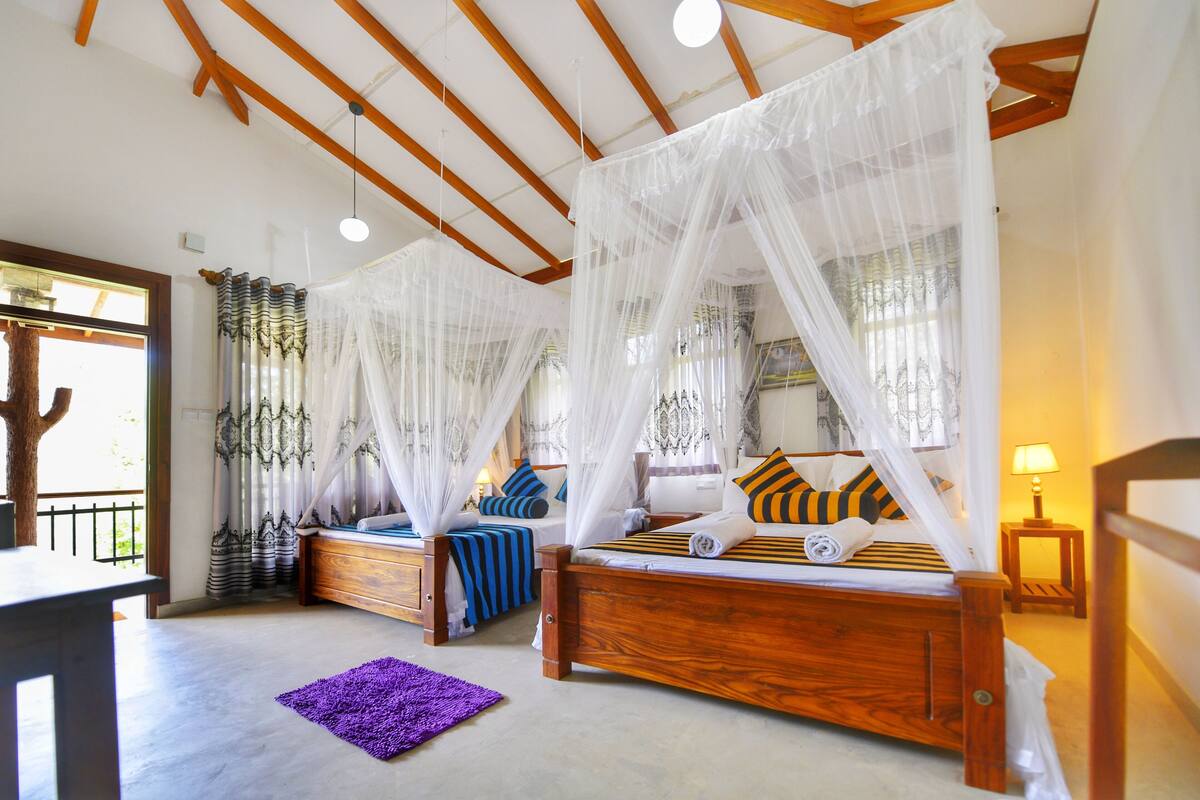 Un dormitorio con dos camas de madera, cada una con dosel, y una alfombra púrpura en el suelo.