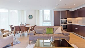 En moderne stue med sofa, sofabord og spiseområde.