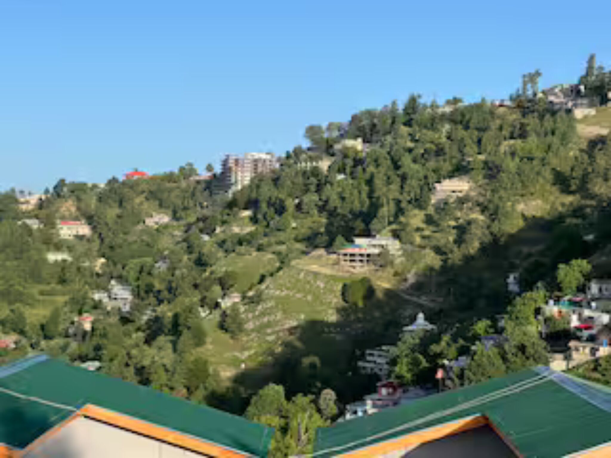 A hillside view with buildings and greenery.