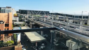 A multi-level highway interchange with vehicles, a McDonald's sign, and a bridge structure. - One Palm Tree Villas Across MNL Airport T3 (Pasay)